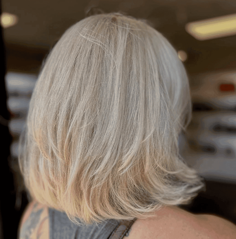 Short blonde hairstyle with layered cut viewed from the back.